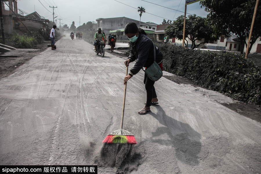 錫納朋火山噴發后 火山灰漫山遍野村民戴口罩清掃